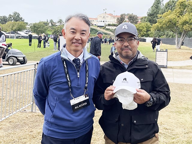 松山選手サイン入りのキャップを手にした筆者の亀田さん（右）。左はRiviera Country Clubの寺嶋さん。